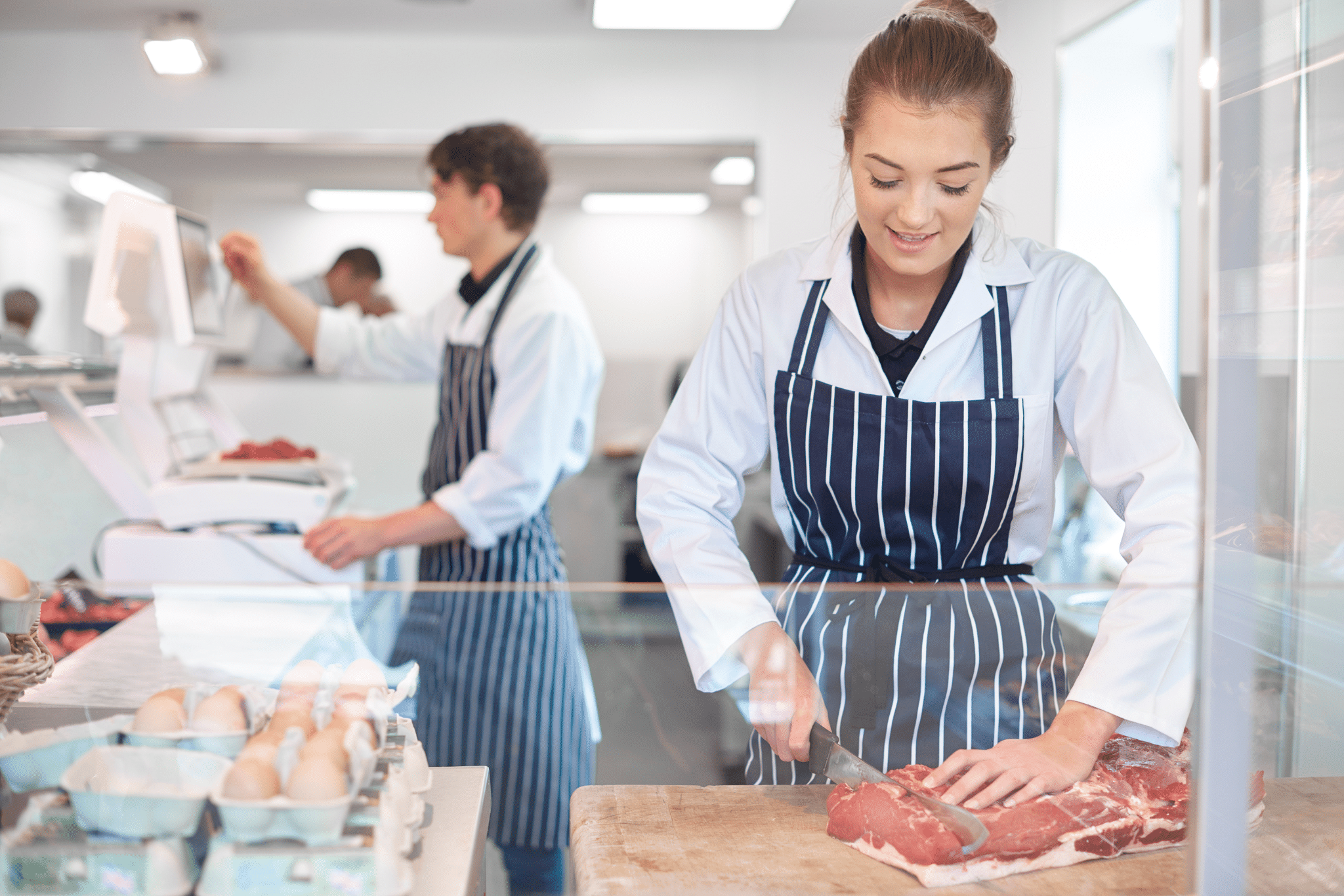 Metzgerin bei der Arbeit in der Metzgerei