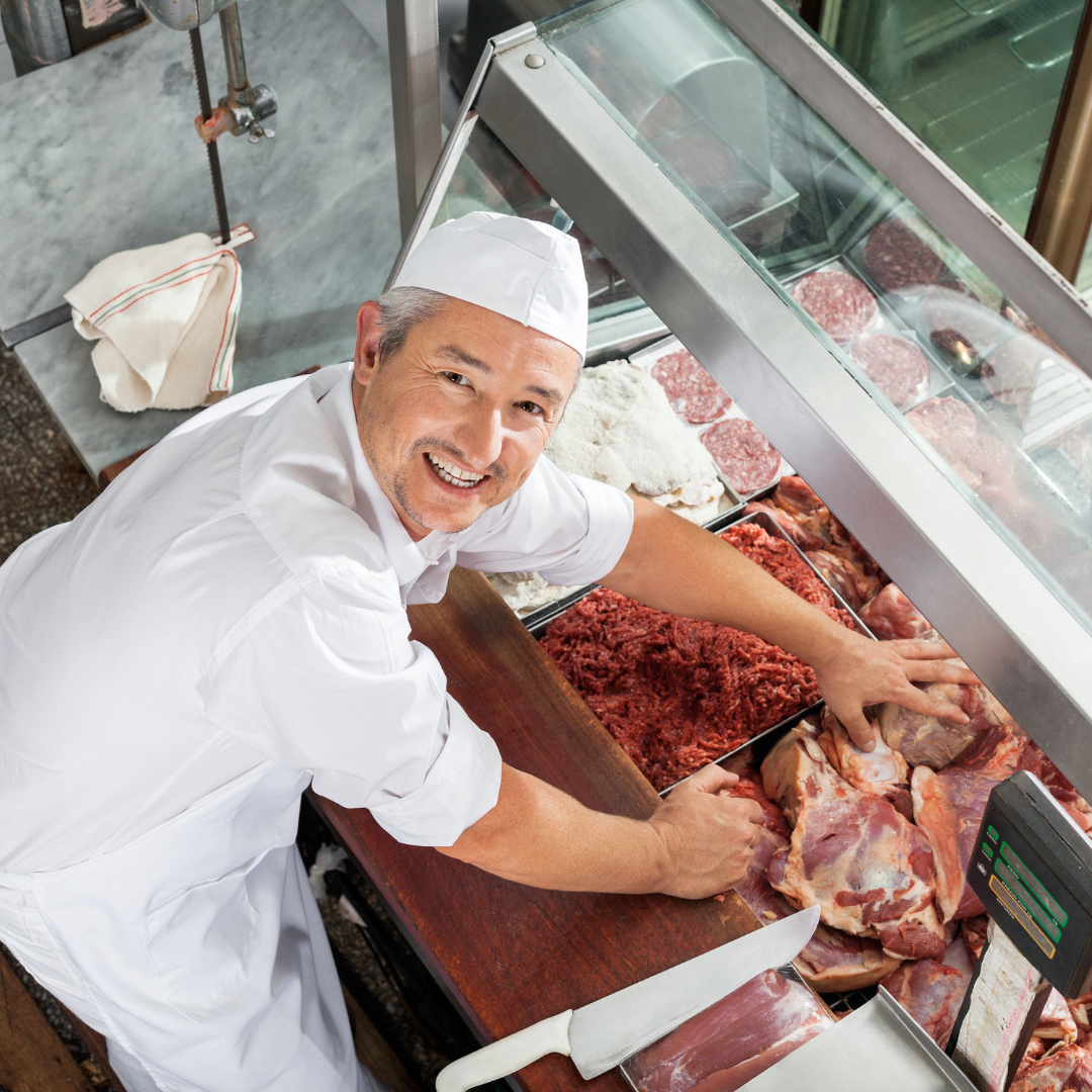 Fleischer bei der Arbeit hinter der Theke